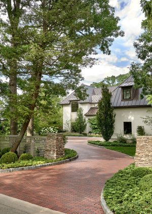 Winding brick driveway surrounded by greenery