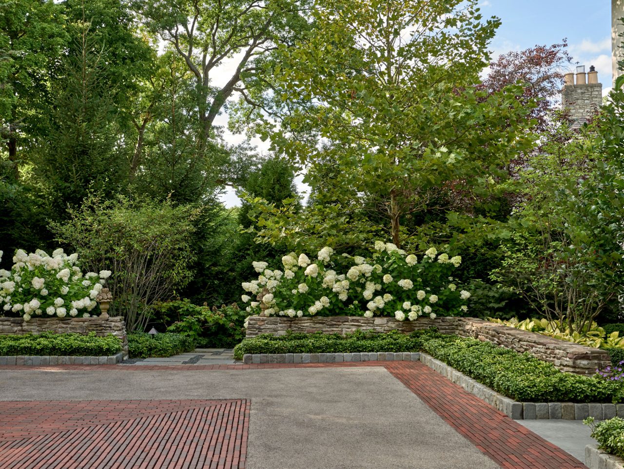Pattern brick driveway with hydrangeas creating a private screen