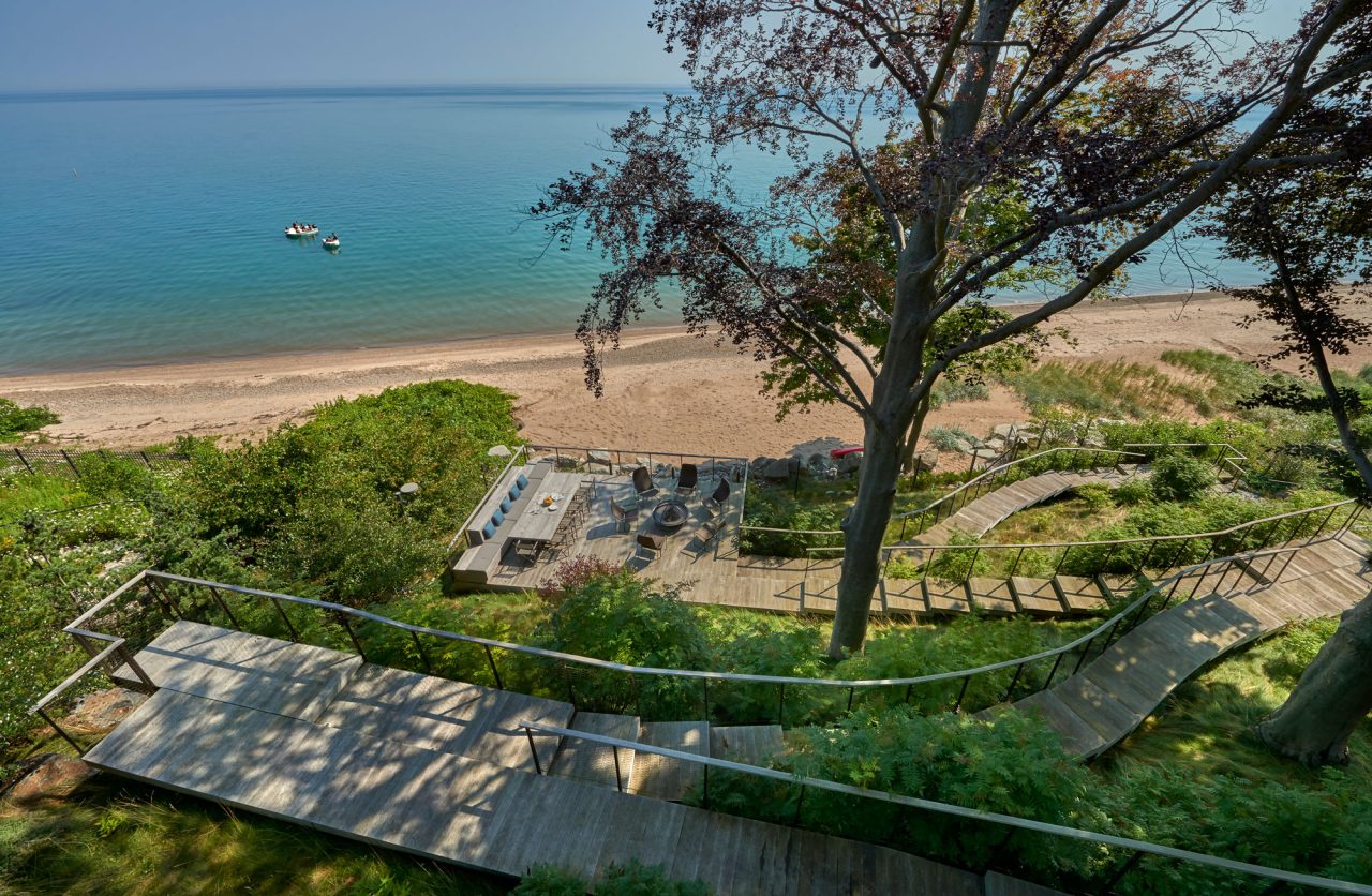 Cliff overlooking Lake Michigan with wooden path leading to the beach.