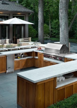Contemporary outdoor kitchen custom cabinetry with bluestone paving