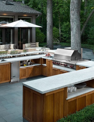 Contemporary outdoor kitchen custom cabinetry with bluestone paving