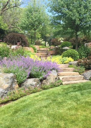 Natural stone staircase surrounded by a cottage style perennial garden in the Wisconsin area.
