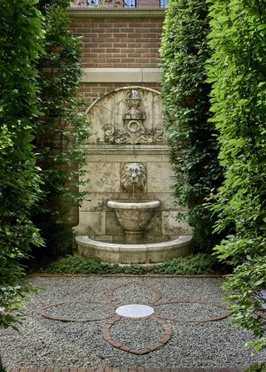 Tuscan-styled, lion-head fountain with gravel and brink inlay
