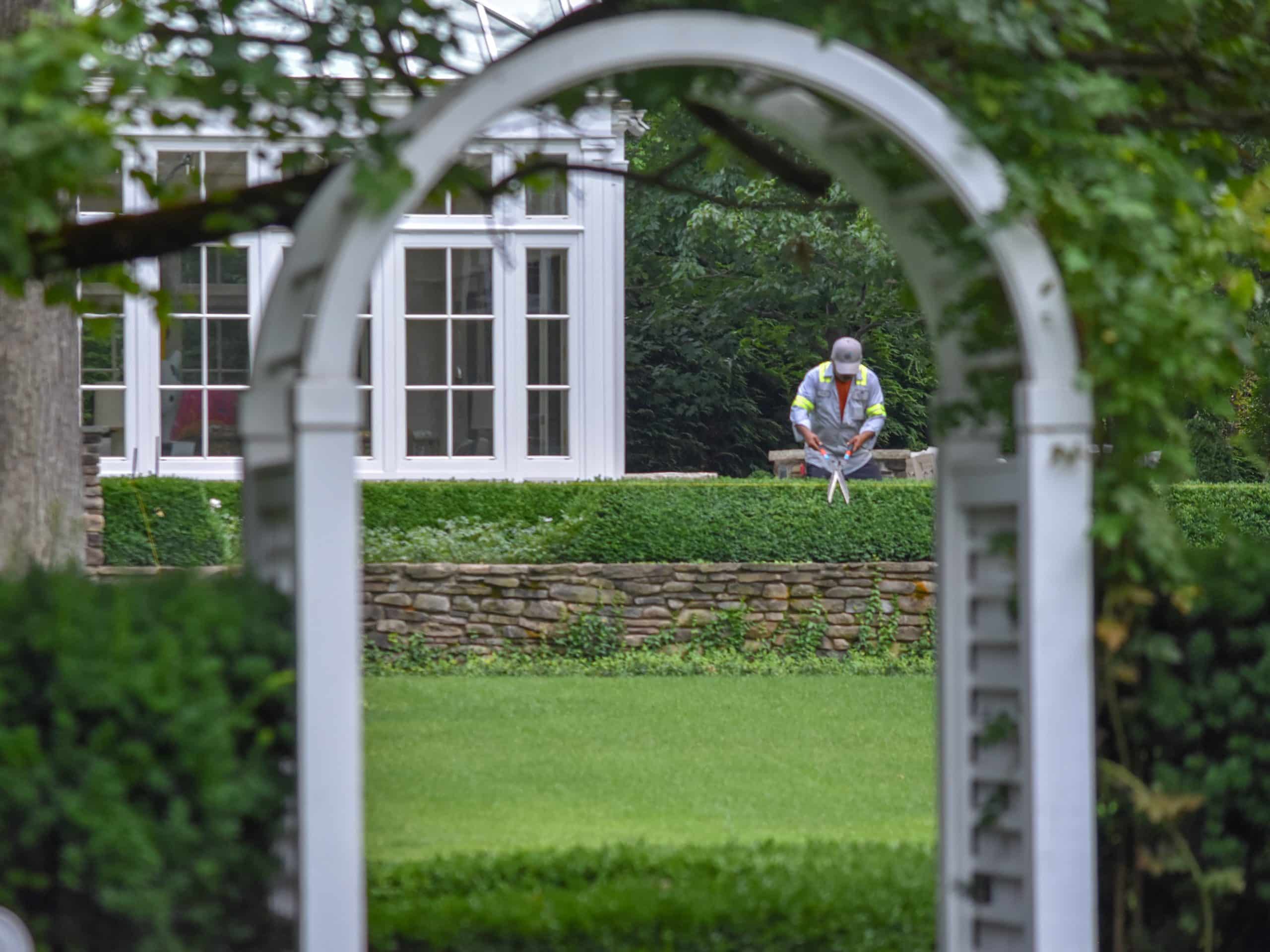 El equipo de mantenimiento paisajístico de Scott Byron &amp; Co. se encarga de plantar y cuidar un parterre formal con setos de boj y plantas de temporada en el centro de Chicago.